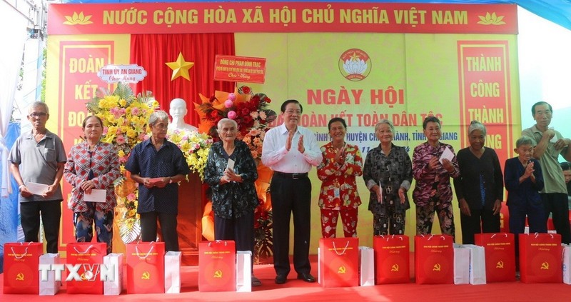 Politburo member Phan Dinh Trac presented gifts to families of policy beneficiaries in Binh Hoa Commune (Photo: VNA)