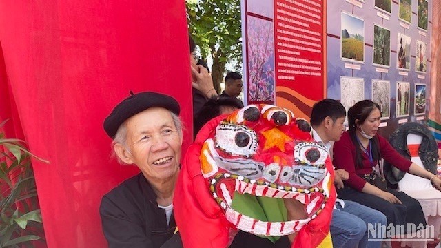 Artisan Hoang Choong poses with a mask at the booth showcasing traditional craft products of Lang Son Province