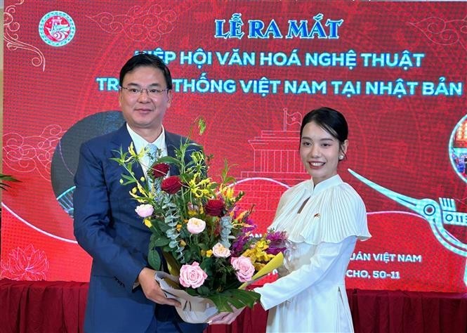 Vietnamese Ambassador to Japan Pham Quang Hieu presents a bouquet to President of the Vietnamese traditional culture and arts association in Japan Do Khanh Han on the occasion of the establishment of the association. (Photo: VNA)