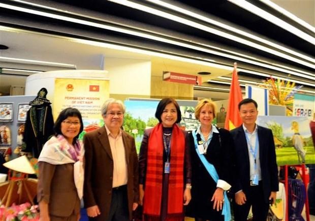 Pham Nam Kim, former director of the Vaud state bank, (second from left), expressing hope that his paintings can help promote the beauty of Vietnamese people as well as renowned landscapes to international friends (Photo: VNA)