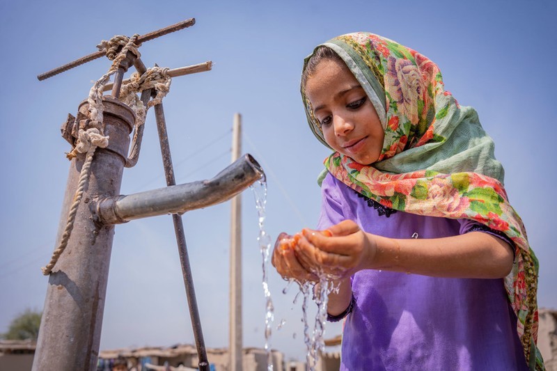 A girl drinking from a hand pump in Pakistan. (Photo: UN)