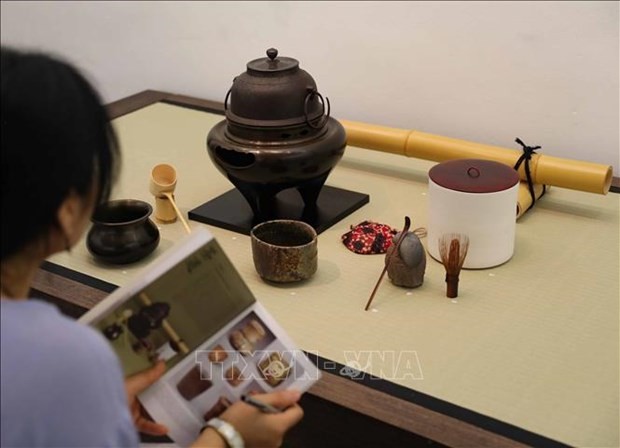 A visitor learn about Japanese pottery products at the exhibition. (Photo: VNA)