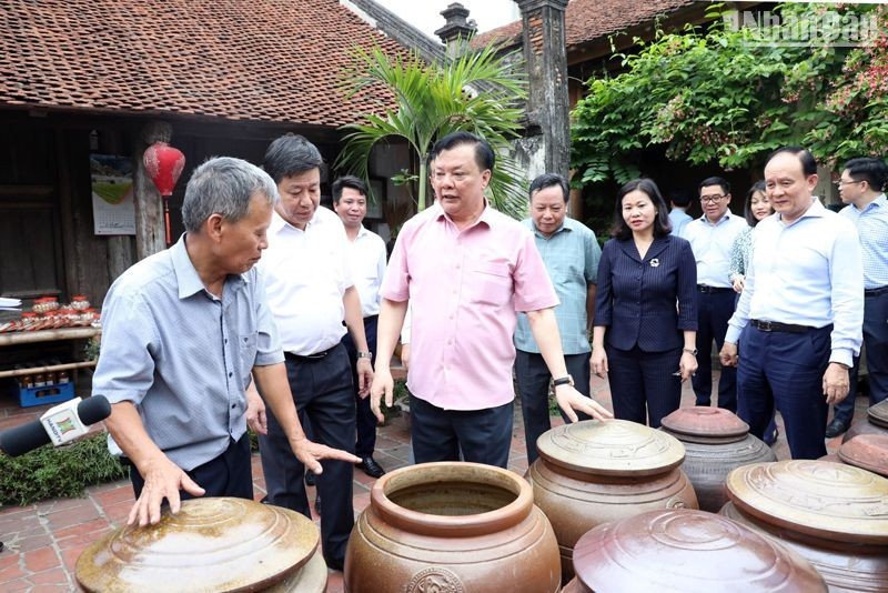 Politburo member and Secretary of Hanoi Party Committee Dinh Tien Dung and local people at the Duong Lam ancient village. (Photo: NDO)