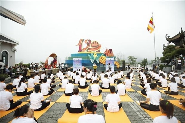 People participate in the yoga performance "Salute to the Sun - Salute to the top of Fansipan" on the summit of Fansipan Mountain in Lao Cai province. (Photo: VNA)