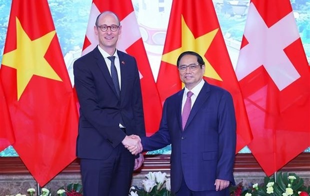 Prime Minister Pham Minh Chinh (R) welcomes President of the Swiss National Council Martin Candinas in Hanoi on June 30 (Photo: VNA)