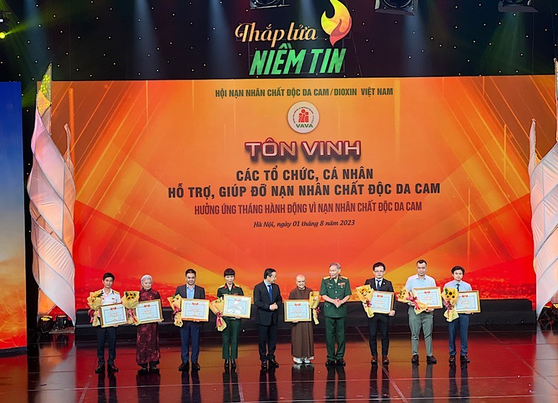 Deputy Prime Minister Tran Hong Ha and Senior Lieutenant General Nguyen Van Rinh present certificates of merit to organisations and individuals who have supported AO victims.