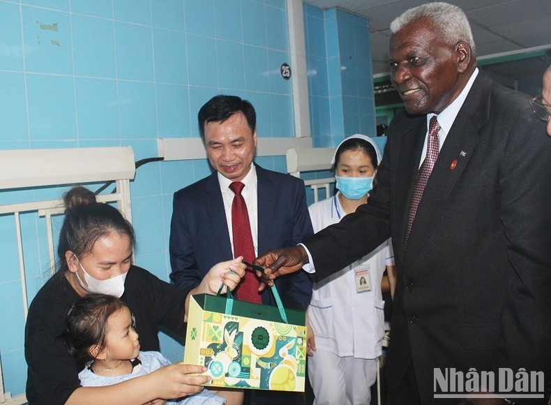 President of the National Assembly of People's Power of Cuba Esteban Lazo Hernandez presents a gift to a child patient treated at the hospital. (Photo: NDO)
