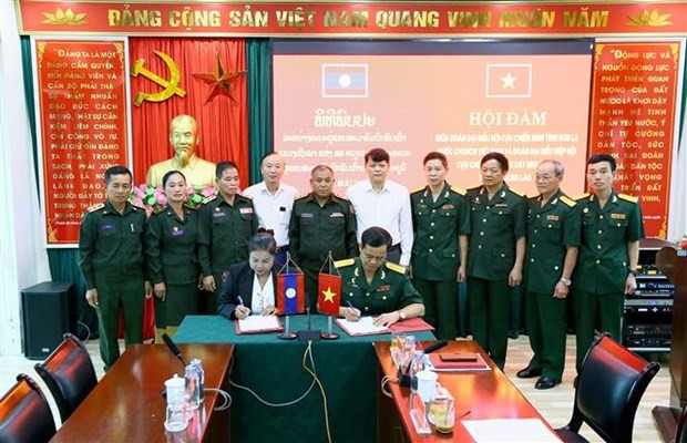 Representatives from the veterans associations of Son La and Laos' Xayabury province sign the agreement. (Photo: VNA)