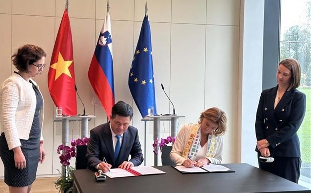 Minister of Industry and Trade Nguyen Hong Dien (L) and Slovenian Deputy Prime Minister and Minister of Foreign Affairs Tanja Fajon sign minutes of the third meeting (Photo: VNA)