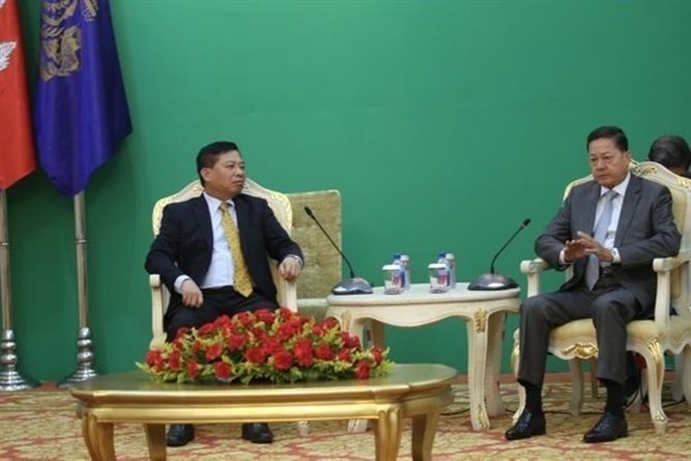 Cambodian Deputy Prime Minister Neth Savoeun (R) receives Vietnamese Ambassador Nguyen Huy Tang in Phnom Penh on December 5. (Photo: VNA)