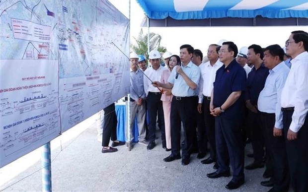 National Assembly Chairman Vuong Dinh Hue (front row, dark shirt) checks the project progress on a map. (Photo: VNA)