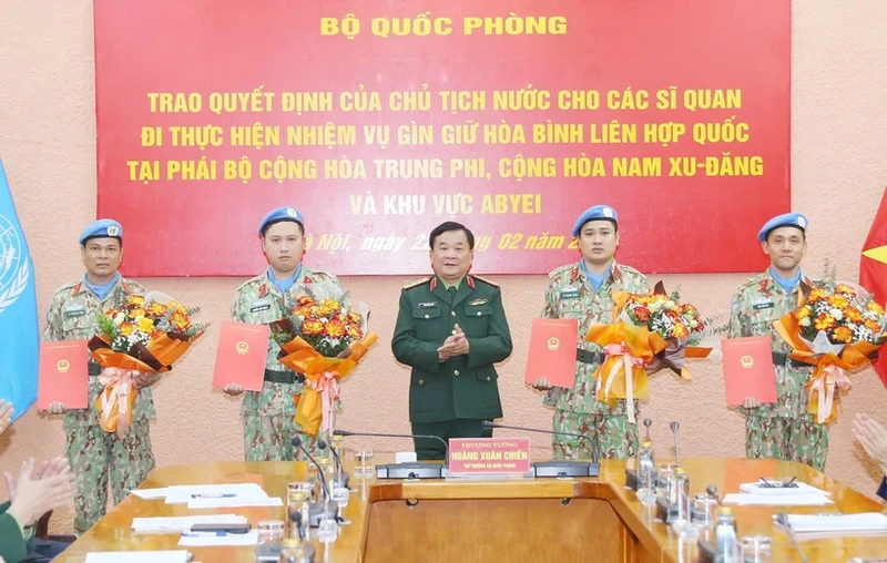 Deputy Minister of National Defence Sen. Lieut. Gen Hoang Xuan Chien (middle) presents the President's decision to four military officers (Photo: VNA)