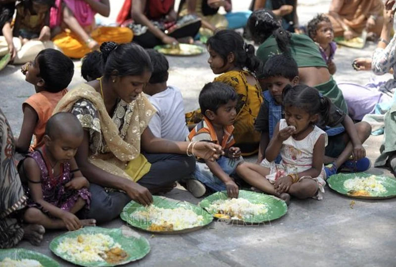 Homeless people receive food from a relief programme in Hyderabad, India. (Illustrative image. Photo: AFP/VNA)