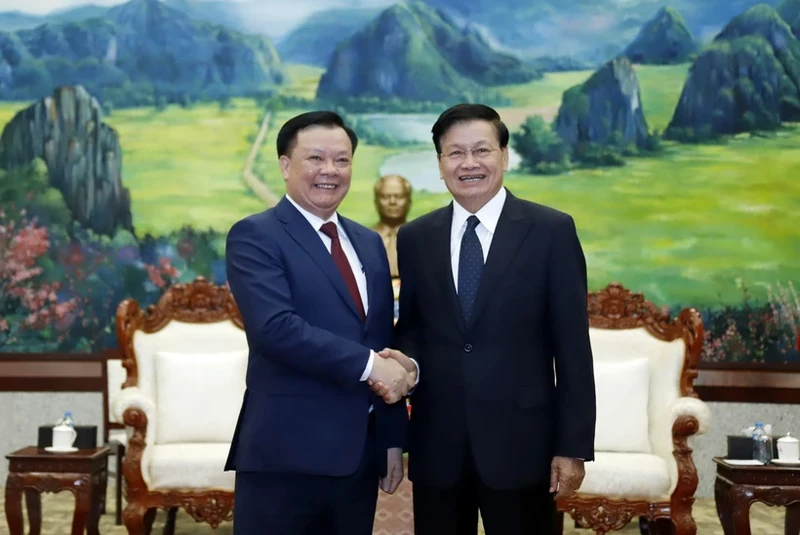 General Secretary of the Lao People’s Revolutionary Party and President of Laos Thongloun Sisoulith (R) welcomes Dinh Tien Dung, Politburo member of the Communist Party of Vietnam and Secretary of the municipal Party Committee, at the meeting in Vientiane on March 12. (Photo: VNA)