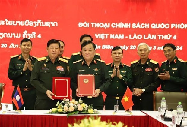 Deputy Defence Minister Sen. Lieut. Gen. Hoang Xuan Chien and his Lao counterpart Vongkham Phommakone sign a minute of the dialogue (Photo: VNA)