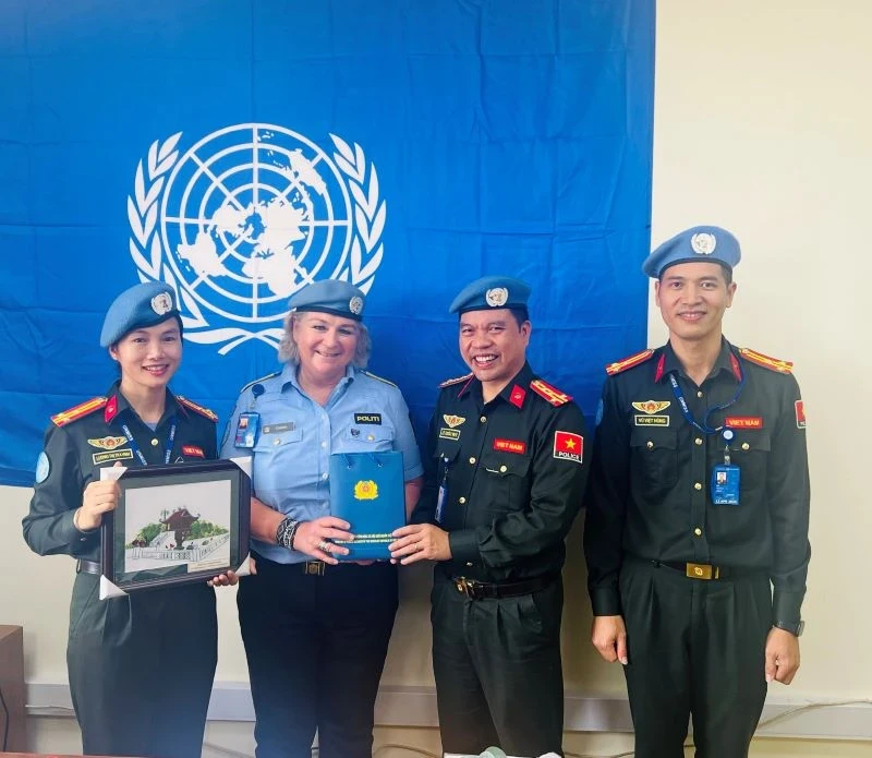 Christine Fossen, Police Commissioner, United Nations Mission in South Sudan (UNMISS), presents certificates of merit to three officers from the Vietnamese Ministry of Public Security.