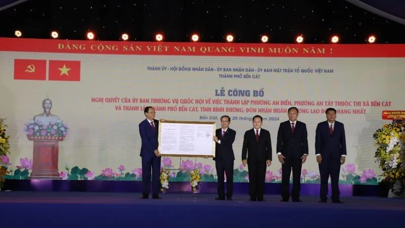 Vice Chairman of the National Assembly Tran Quang Phuong (left) hands over the decision on the establishment on Ben Cat city to the local authorities.
