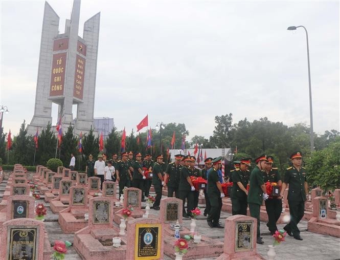 Memorial and burial service for the remains of 87 Vietnamese volunteer soldiers and experts (Photo: VNA)