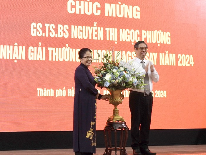 Nguyen Phuoc Loc, Deputy Secretary of the Ho Chi Minh City Party Committee presents flowers to Prof., Dr. Nguyen Thi Ngoc Phuong (Photo: giaoduc.edu.vn)