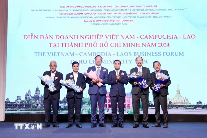 Vice Chairman of the Ho Chi Minh City People's Committee Bui Xuan Cuong (3rd from right) gives flowers to representatives of the forum organising board. (Photo: VNA)