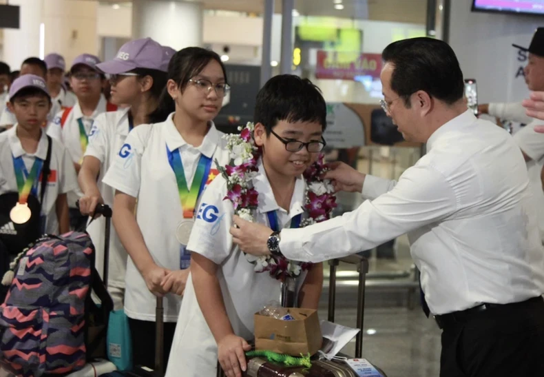 Director of the Hanoi Department of Education and Training Tran The Cuong welcomes the Vietnamese team returning from the 21st IMSO. (Photo: VNA)