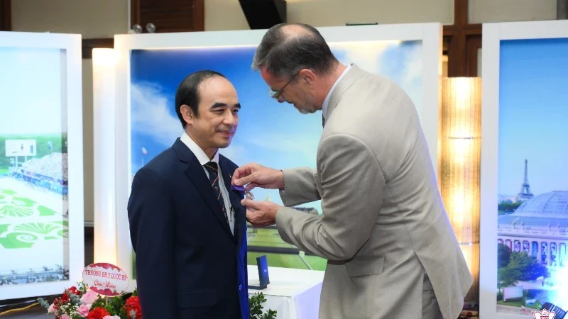 French Ambassador to Vietnam, Olivier Brochet, presents the Order of Academic Palms to Professor Dr Nguyen Huu Tu 