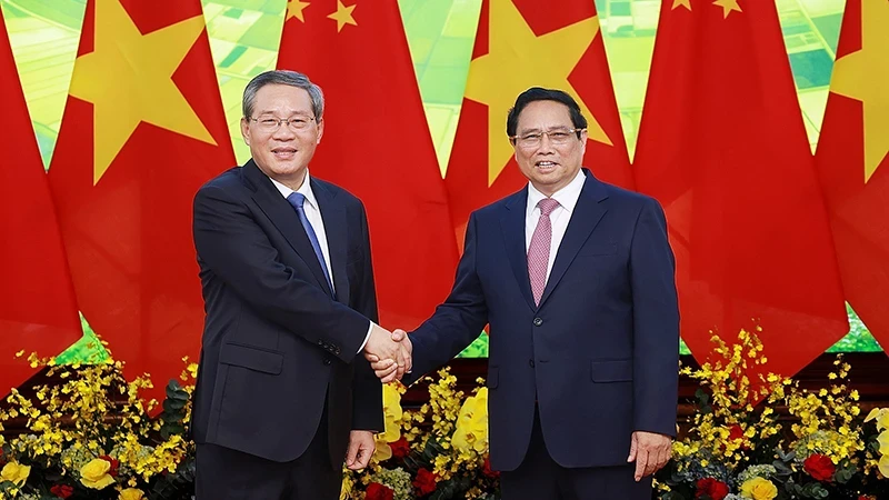 Prime Minister Pham Minh Chinh (R) shakes hands with Chinese Premier Li Qiang. (Photo: VNA)