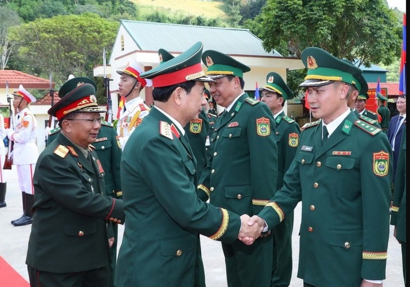 General Phan Van Giang and Lao Deputy Prime Minister and Minister of National Defence General Chansamone Chanyalath greet military officials at the second Vietnam-Laos border defence friendship exchange on October 22 (Photo: VNA)