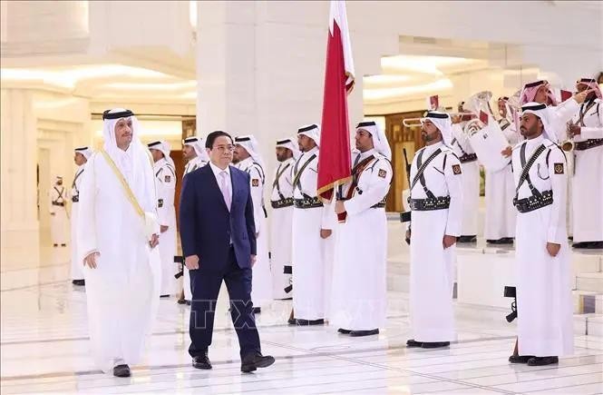 Prime Minister Pham Minh Chinh (right) and his Qatari counterpart Sheikh Mohammed bin Abdulrahman bin Jasim Al-Thani inspect the guard of honour. (Photo: VNA)