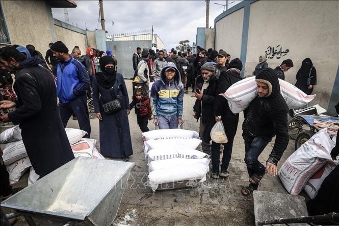 Palestinian refugees in the city of Rafah, located in the Gaza Strip, receive humanitarian aid distributed by the United Nations Relief and Works Agency for Palestine Refugees in the Near East (UNRWA). (Photo: AFP/VNA)