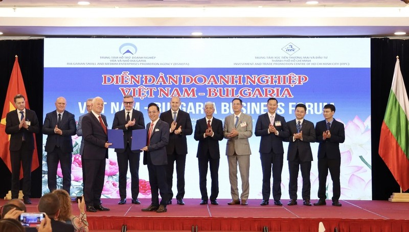 Bulgarian President Rumen Radev (sixth from the right) and other delegates witness representatives of Vietnamese and Bulgarian businesses exchanging cooperation agreements at the forum. (Photo: VNA)