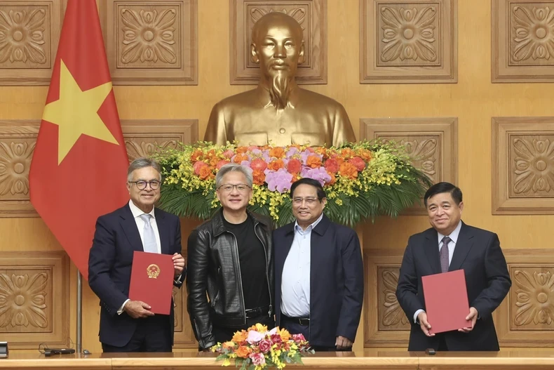 Prime Minister Phạm Minh Chính (second from right) and NVIDIA founder and chief executive officer Jensen Huang (second from left) witness the signing of a cooperation agreement on artificial intelligence research between Vietnamese government and NVIDIA Group. (Photo: VNA)