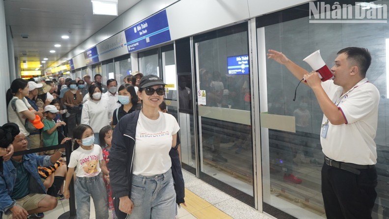 People queue up to board the train at Ben Thanh Station on the first day of operation of Metro Line 1 (Photo: NDO)