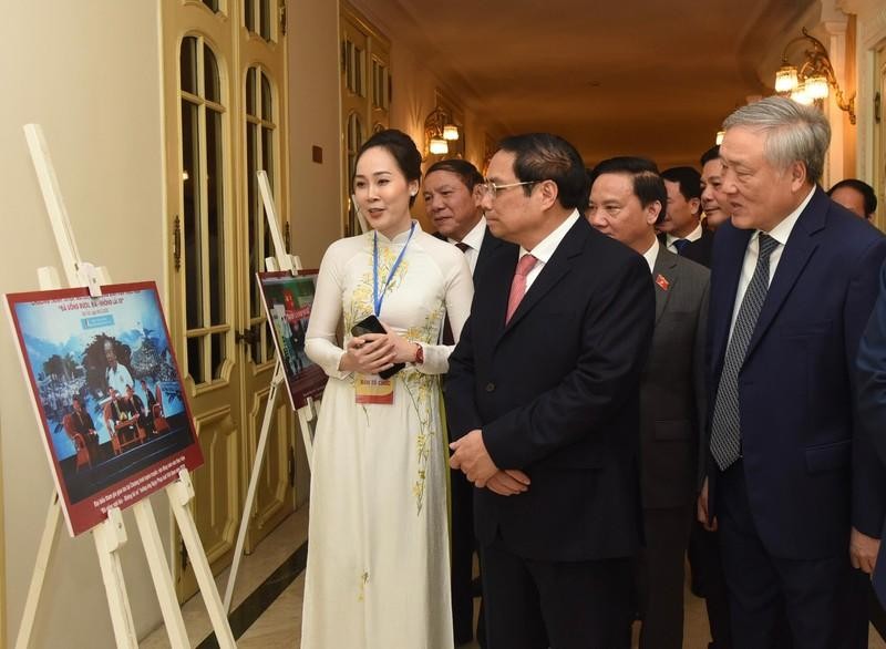 PM Pham Minh Chinh visits a photo exhibition at the meeting. (Photo: Tran Hai)