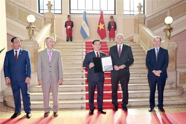 Governor of Santa Fe Omar Ángel Perotti (2nd from R) awards the title of Honorary Guest to National Assembly Chairman Vuong Dinh Hue (Photo: VNA)