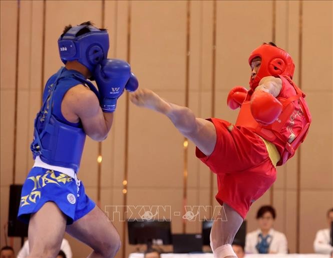 Bui Truong Giang (in red) brought home the fourth gold for Vietnamese Wushu team after taking down Gideon Fred Wayan Padua of the Philippines in combat event. (Photo: VNA)