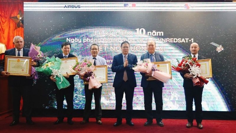 VAST President Chau Van Minh presents flowers and certificates of merits to contributors to the VNREDSat-1 project.