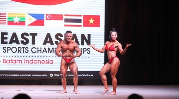 Nguyen Thi Cam Tu (R) and Tran Bao Quoc Vuong win their mixed pair title at the 17th Southeast Asian Bodybuilding and Physique Sports Championship. (Photo of WBPF Championship)