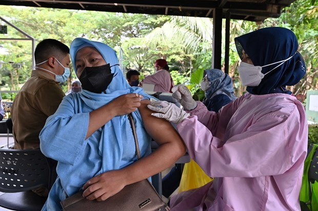 A health worker injects COVID-19 vaccine for a resident in Jakarta, Indonesia. (Photo: AFP/VNA)