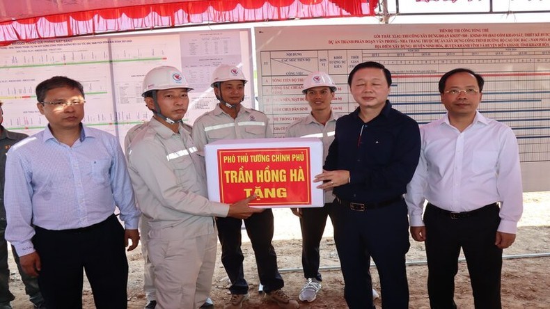 Deputy PM Tran Hong Ha presents gifts to workers and engineers at the construction site.
