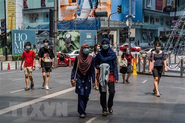 People walk on a street in Kuala Lumpur (Photo: AFP/VNA)
