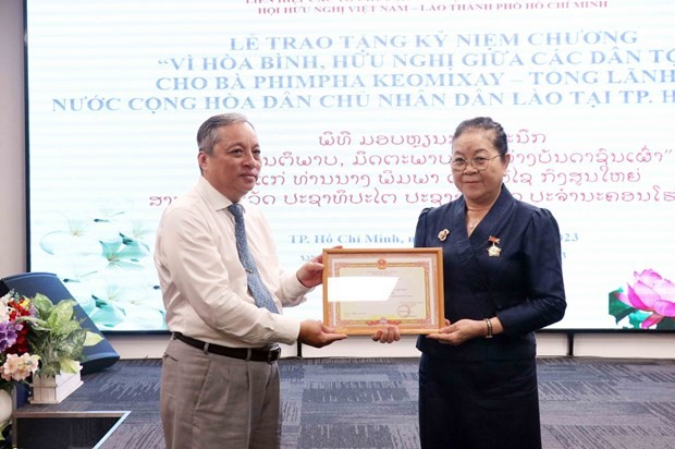Lao Consul General in Ho Chi Minh City Phimpha Keomixay (R) is awarded an insignia “For peace and friendship among nations” by the Vietnam Union of Friendship Organisations (VUFO) on August 22. (Photo: VNA)