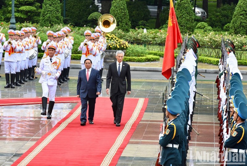 Prime Minister Pham Minh Chinh and his Singaporean counterpart Lee Hsien Loong review the guard of honour. (Photo: Tran Hai)