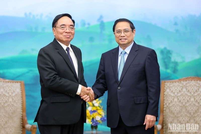 Prime Minister Pham Minh Chinh shakes hands with Lao Minister of Planning and Investment Khamchen Vongphosy. (Photo: Tran Hai) 