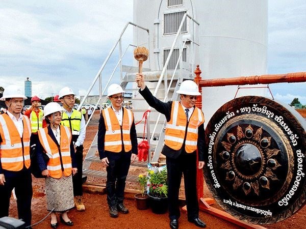 Lao Prime Minister Sonexay Siphandone strikes the gong to mark the opening of the first turbine of the Monsoon Wind Power Project in Xekong province. (Photo: Vientiane Times)