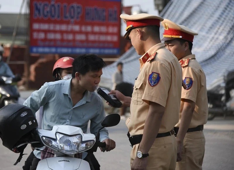 Dien Bien traffic police officers conduct an alcohol breath test on a motorist. (Photo: VNA) 