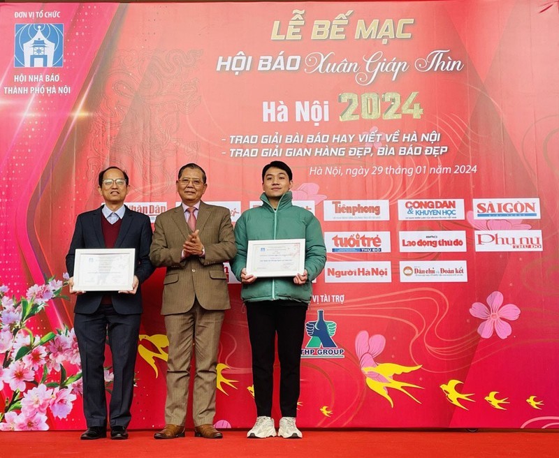 A Nhan Dan representative receives the first prize for beautiful display booth.