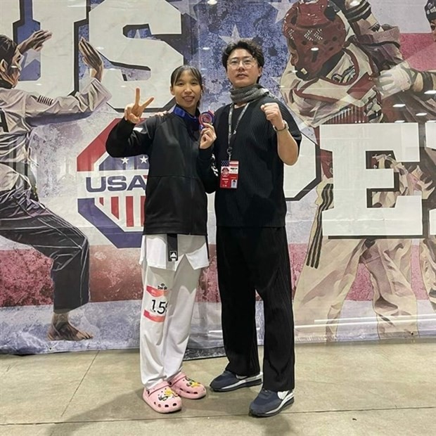 Taekwondo fighter Truong Thi Kim Tuyen (left) and her coach pose for photo after winning a silver at the US Open taekwondo tournament on February 19 in Nevada. (Photo courtesy of Truong Thi Kim Tuyen)