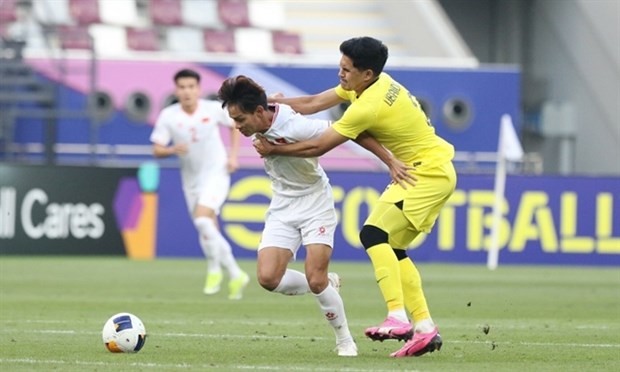 Bui Vi Hao (11) and his teammates encounter a tough early game against Malaysia, but ultimately came out on top. (Photo: VNA)