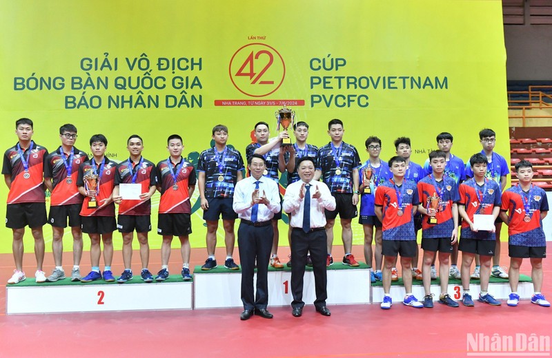 Nhan Dan's Deputy Editor-in-chief Que Dinh Nguyen presents the cup and medals to the winning teams.